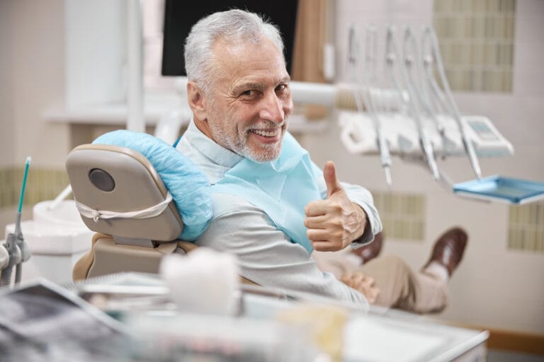 A Man sitting in a dental office with a Confident Smile